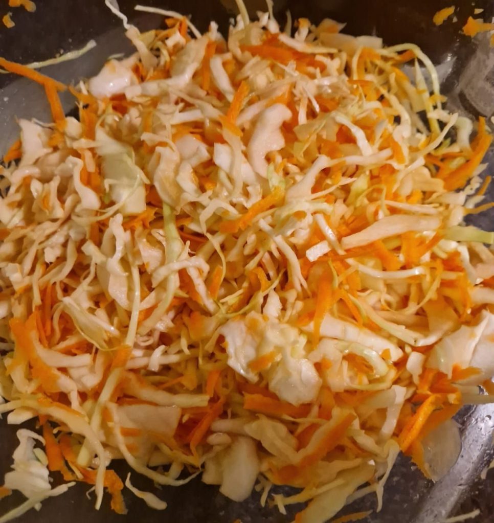 Cut cabbage, carrots, parsley and salt mixed well for coleslaw dish